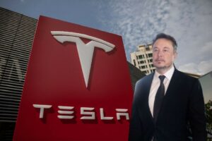 O Έλον Μασκ με φόντο τα κεντρικά γραφεία της Tesla στην Κίνα © EPA/MICHAEL REYNOLDS / ROMAN PILIPEY / EnergyGame.gr